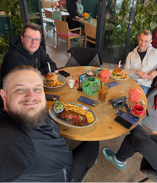 4 people smiling seated at a round table