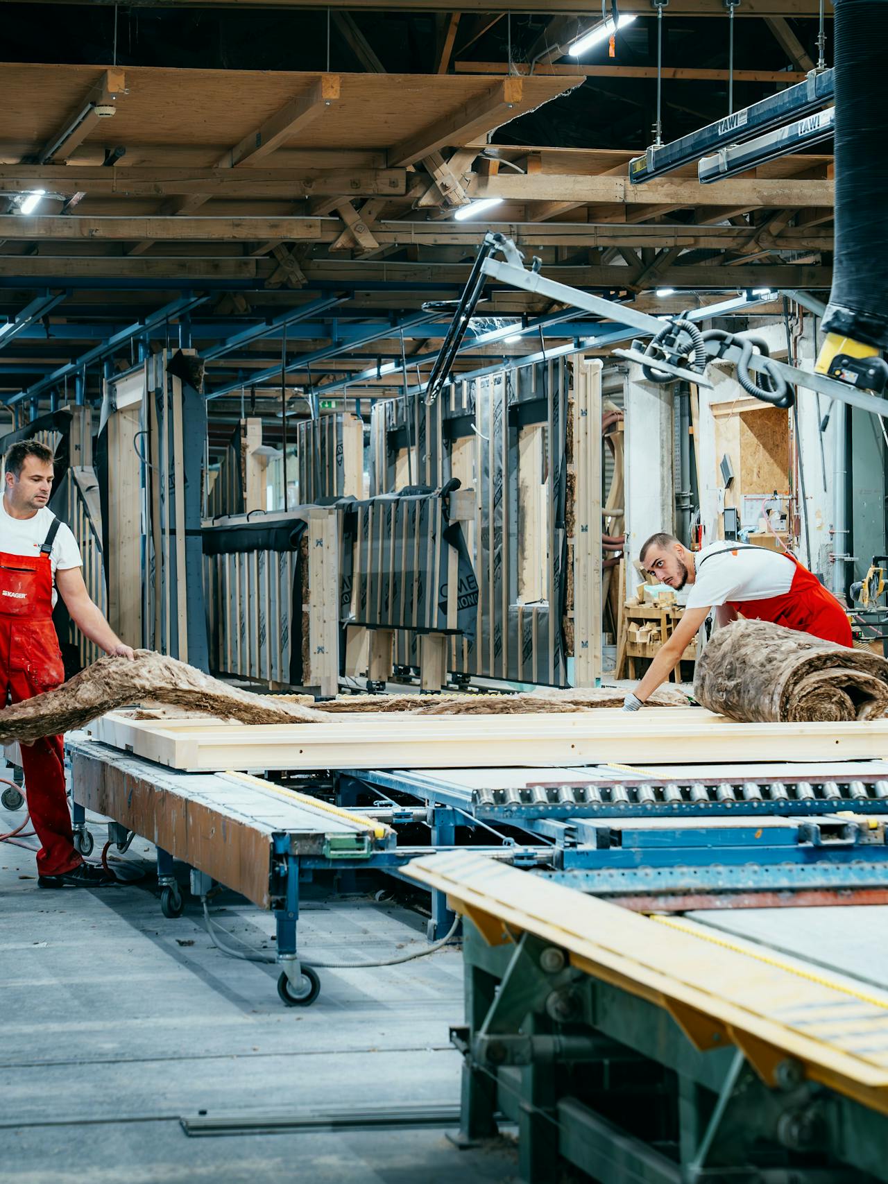Artigiani al lavoro insieme per inserire l'isolamento in un elemento di parete