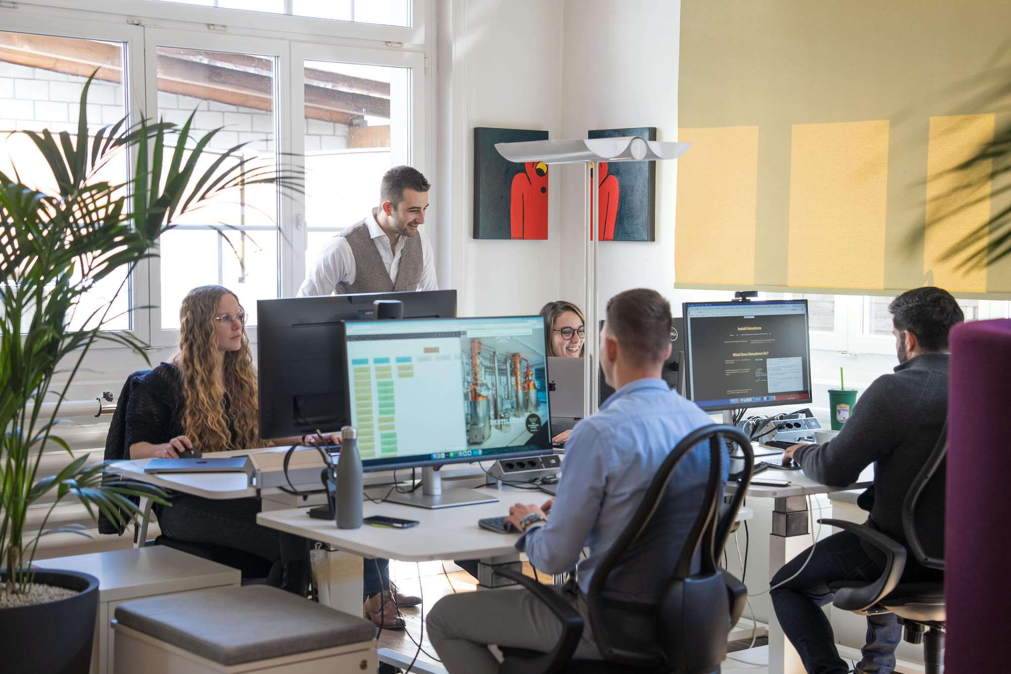 Mitarbeitende von Webwirkung an ihren Arbeitsplätzen im Büro