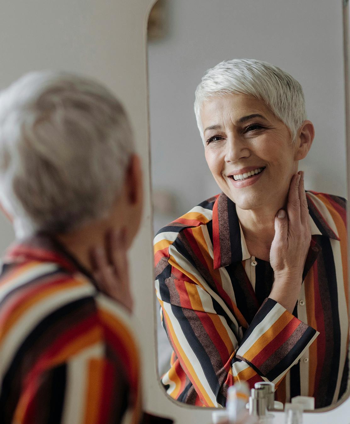 Older lady admiring her neck in mirror