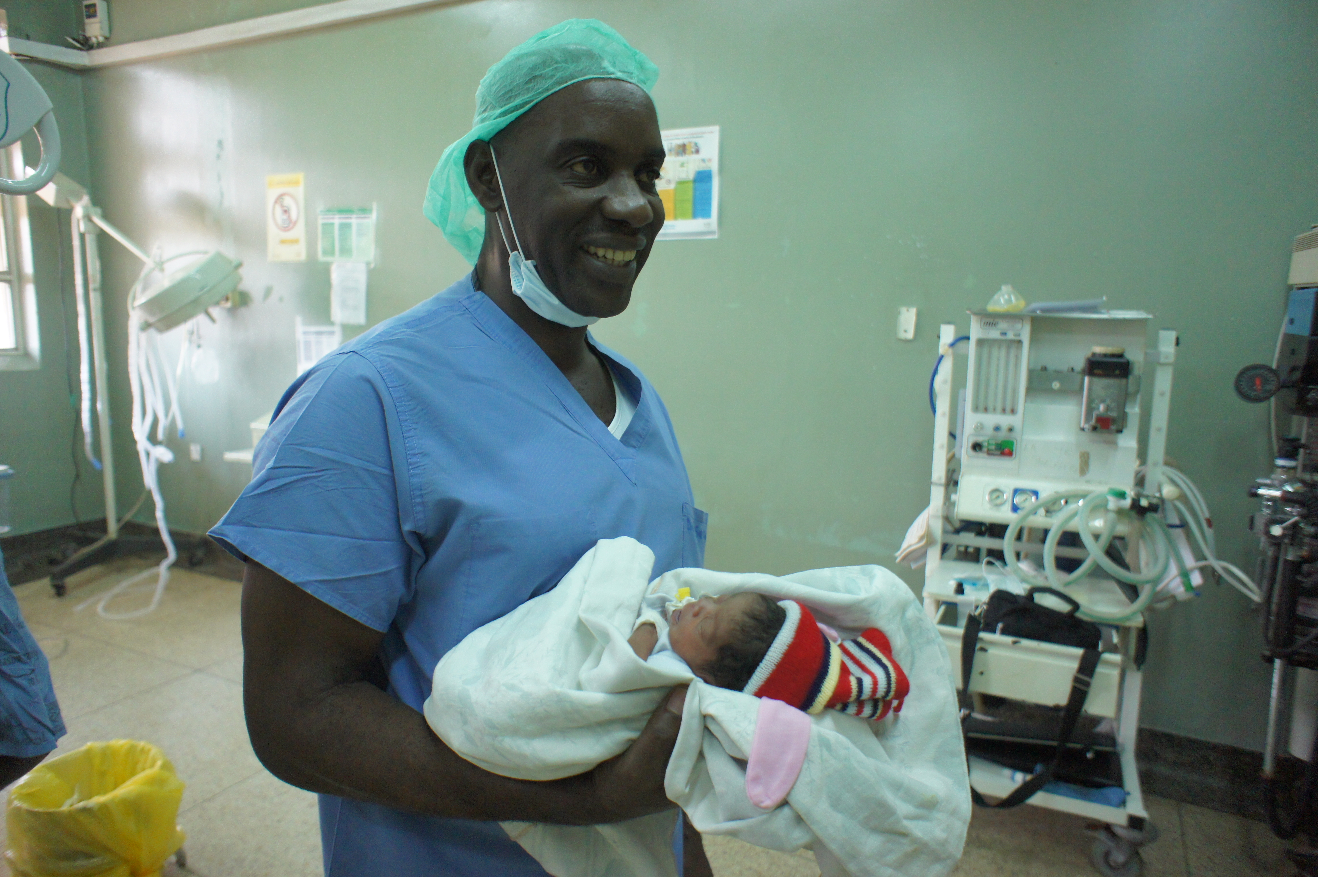 Dr. John Sekabira, in Kampala, Uganda, holding a baby shortly after surgery.