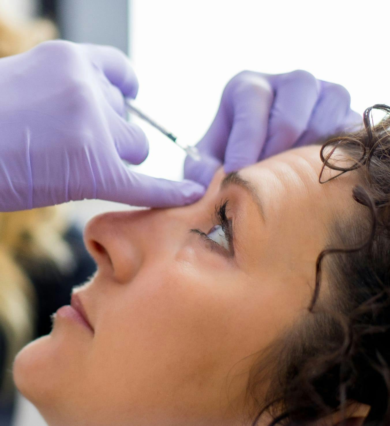Woman getting injection on the forehead