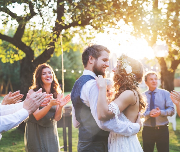 Machen sie die Hochzeit Ihrer Lieben mit Goldgeschenken unvergessen. In einem sonnigen Park, tanzt ein Brautpaar und sieht sich glücklich und verliebt an. Es freut sich über das Gold-Geschenk, was Gäste von ihnen bei Golden Gates erworben haben.