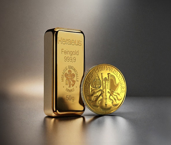 Vor einem dunklen Hintergrund stehen ein Goldbarren und eine Wiener Philharmoniker Goldmünze. Edelmetall-Sparpläne von Golden Gates.