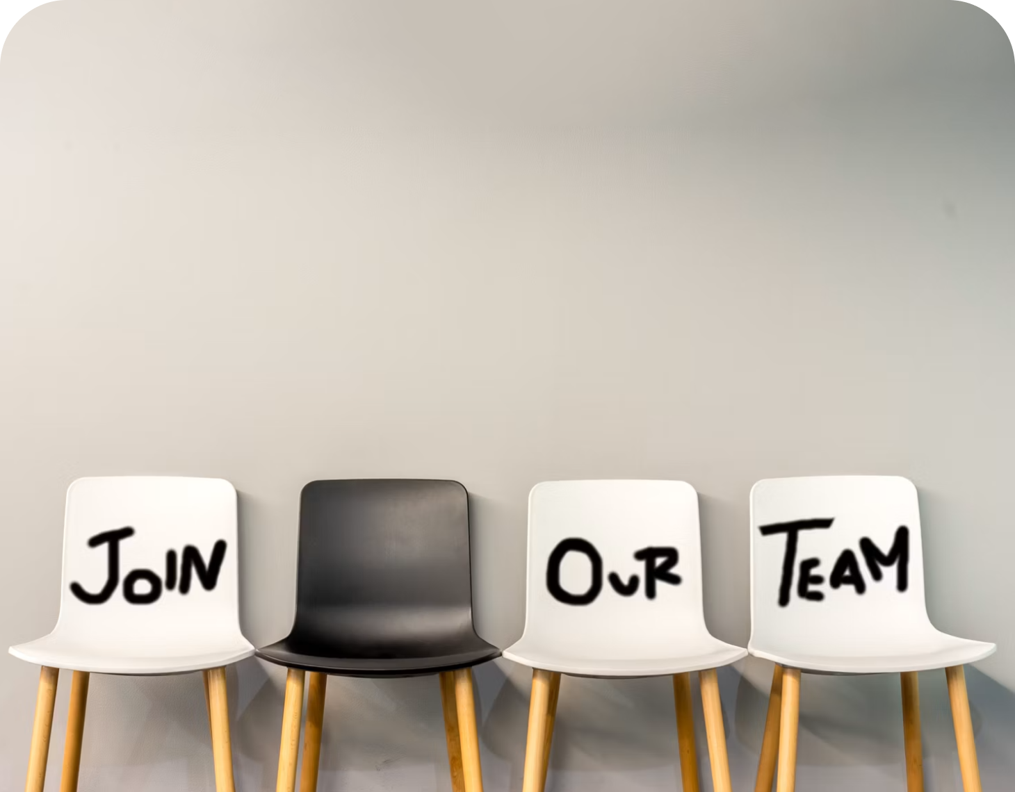 Jobs und Karriere | Golden Gates An einer Wand stehen Stühle auf welche "Join our Team" geschrieben steht. Jobs und Karriere bei Golden Gates.