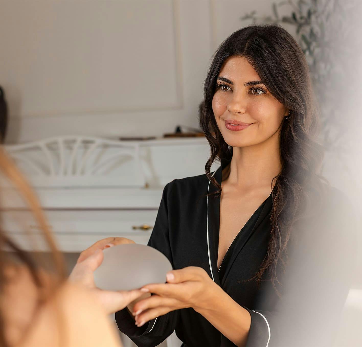 woman getting handed a breast implant