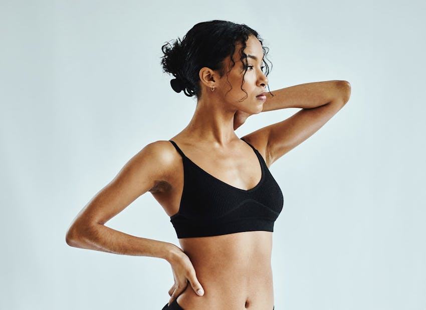 woman with one hand on her hip and the other behind her neck