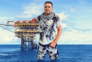 Dale Vince hugging a north sea oil platform
