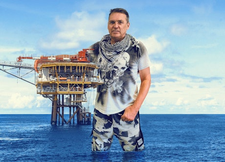 Dale Vince hugging a north sea oil platform