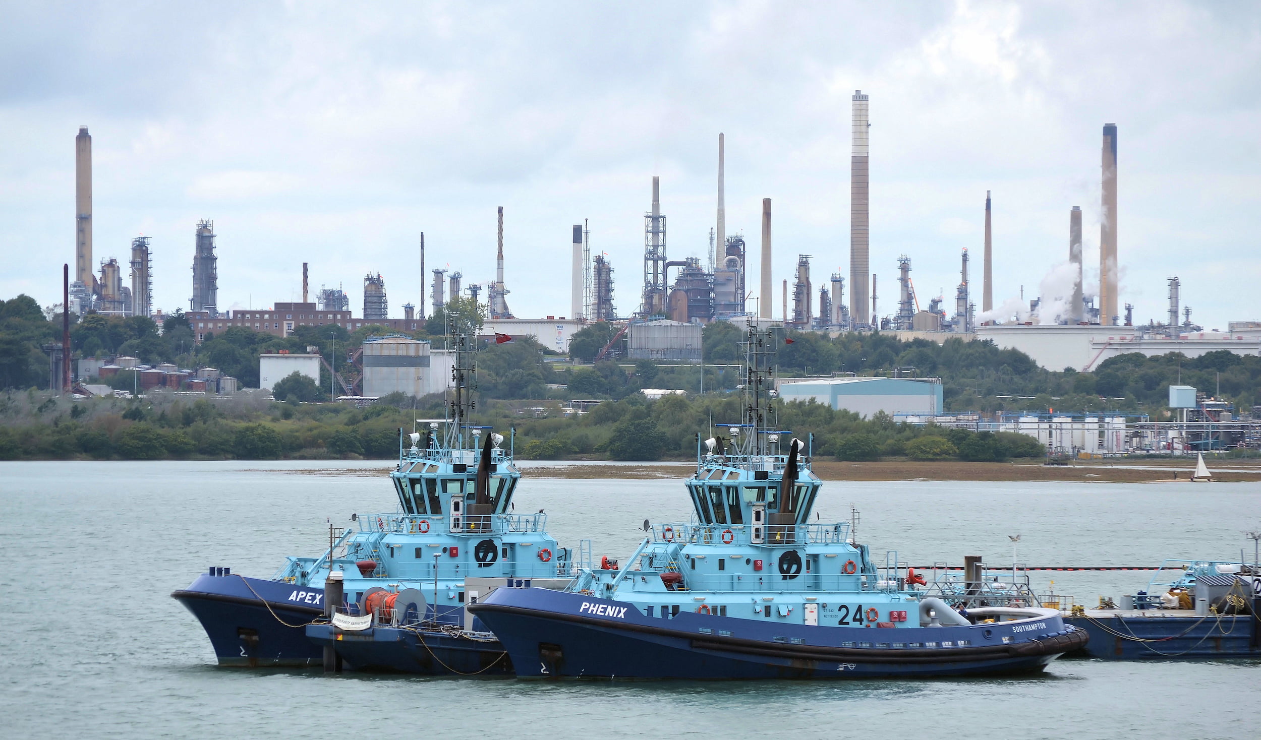 Solent Towage Ltd tugs "Apex" and "Phenix", with Fawley Refinery providing the background. (via Roger Marks, Flickr)