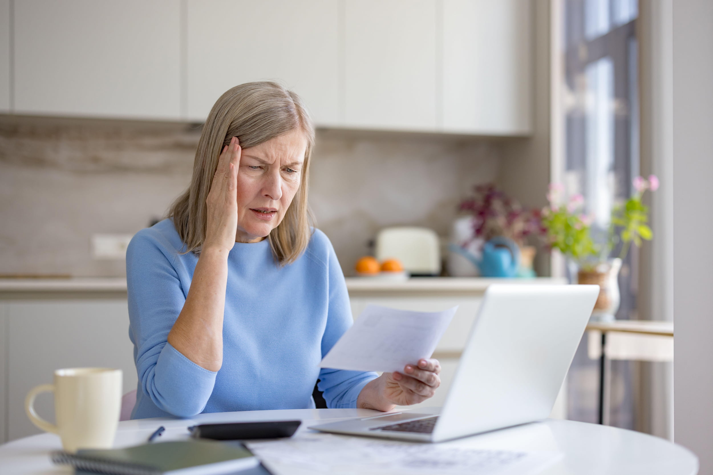 lady with a headache looking at bills