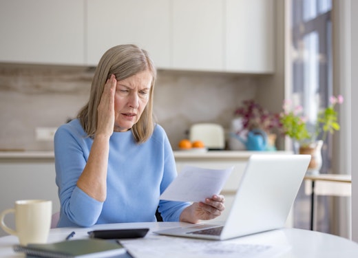 lady with a headache looking at bills