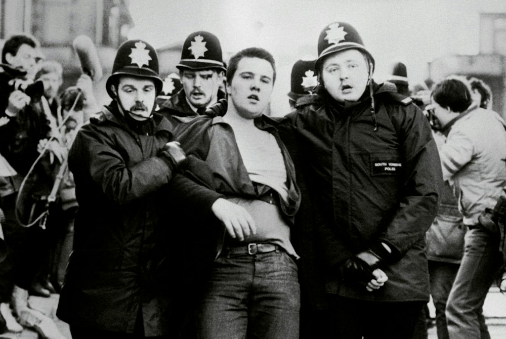 A protester is led away by police officers during clashes with miners in Sheffield in 1984