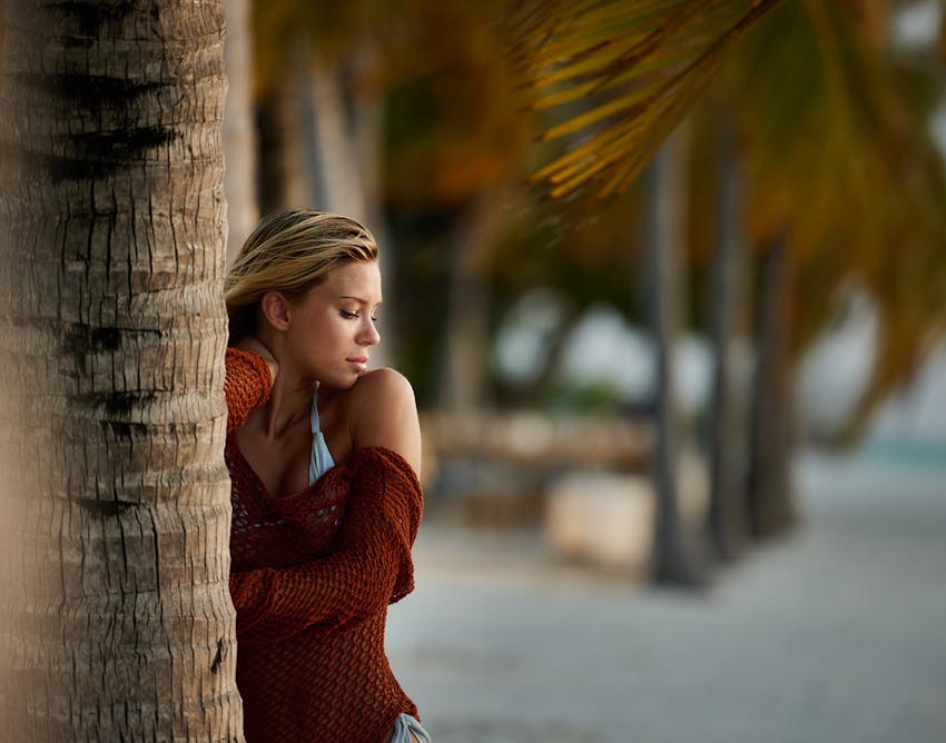 Woman standing behind tree