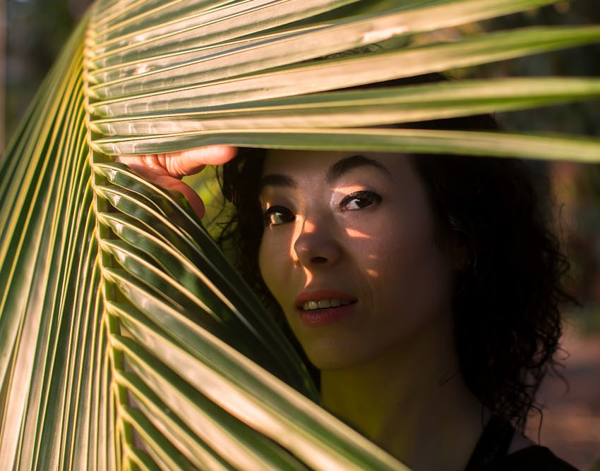 Woman looking through a palm leaf