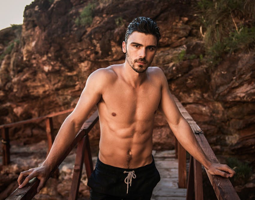 Man posing with his hands on two rails