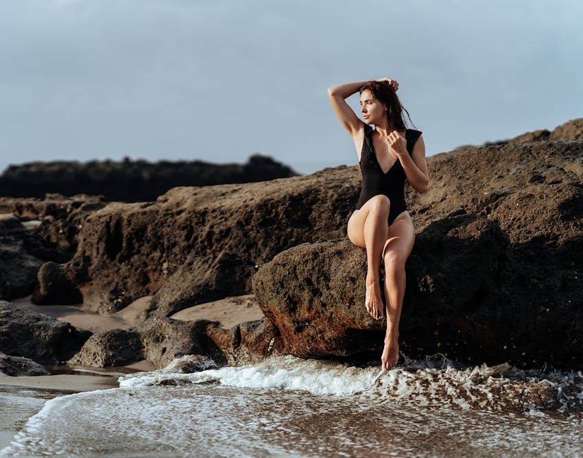 Woman sitting on a rock by the ocean