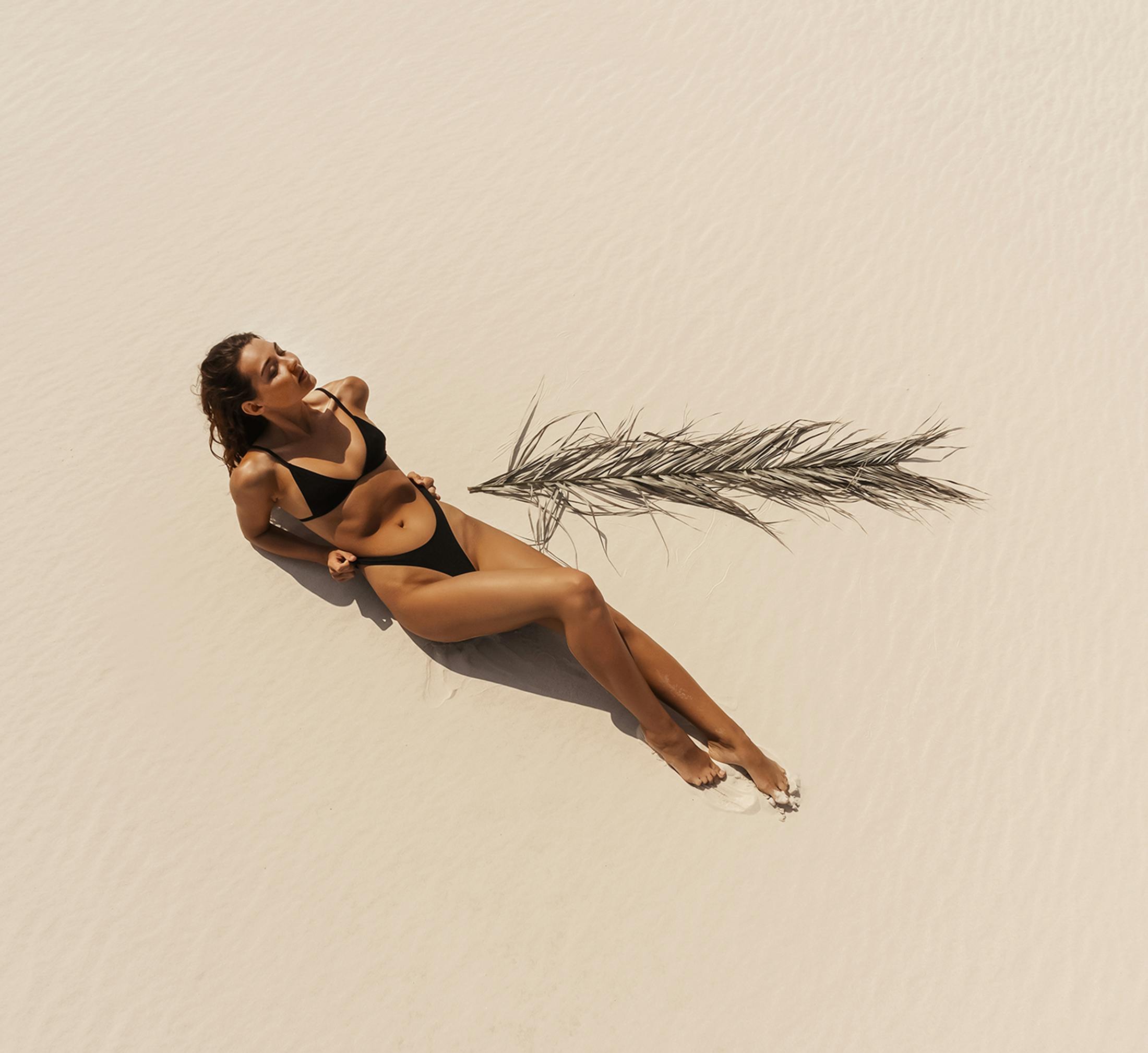 Woman laying down by a palm leaf
