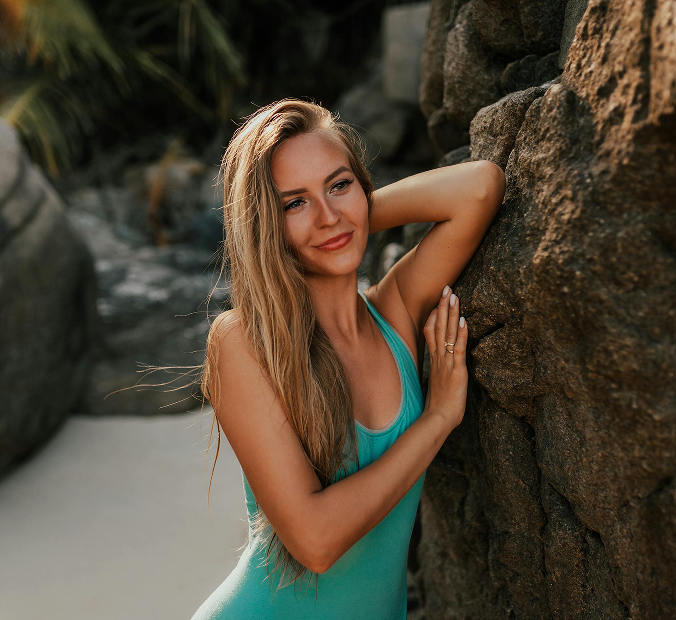 Woman leaning against a rock