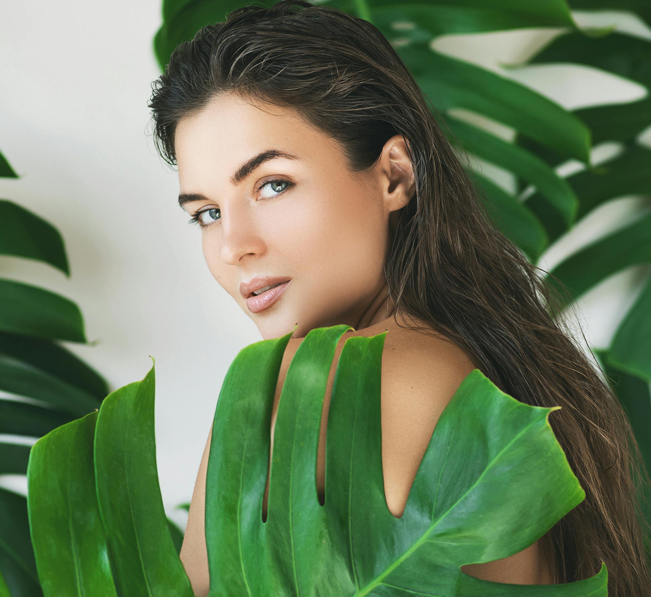 Woman looking over her shoulder surrounded by leaves