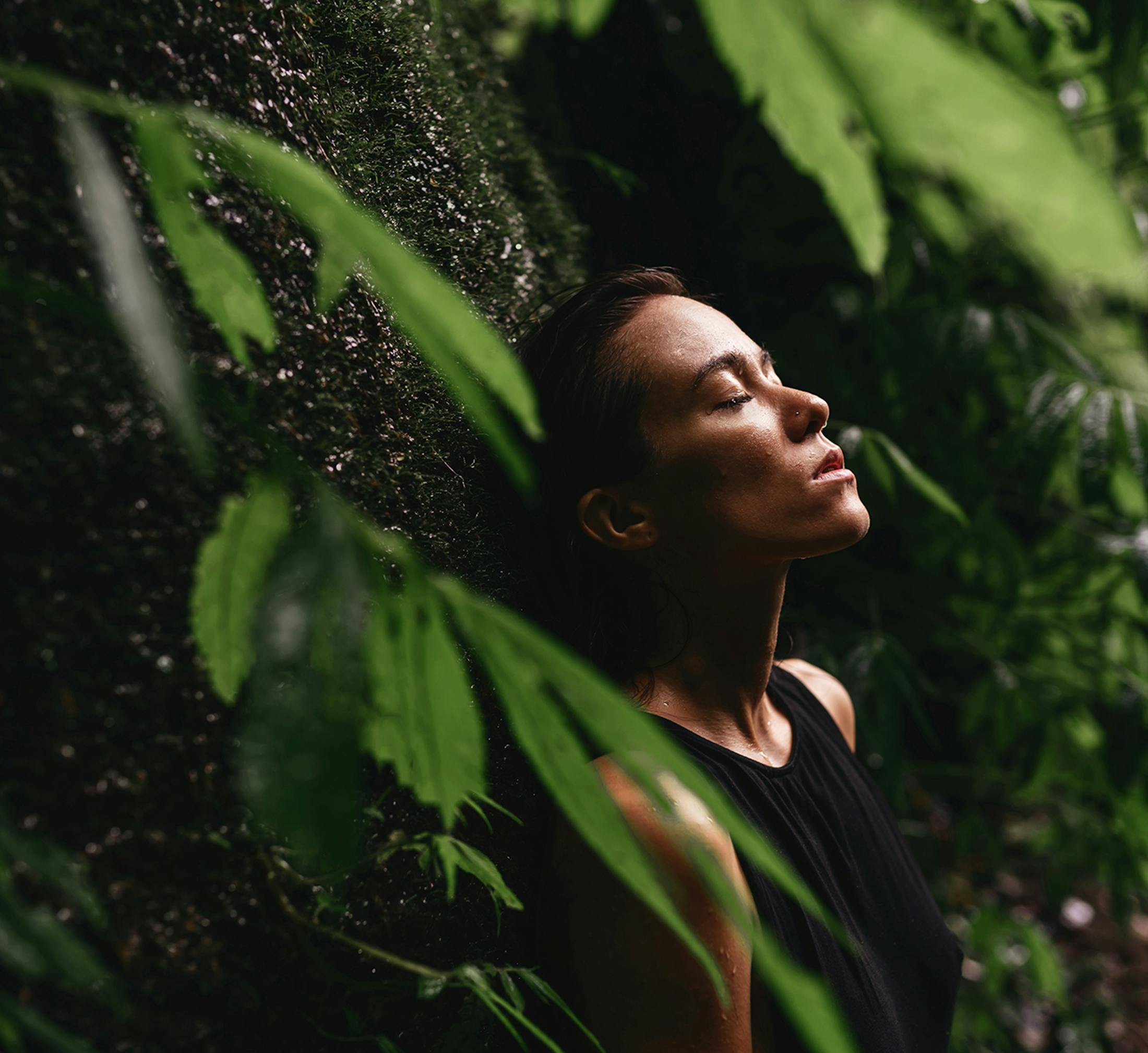 Woman standing with her eyes closed in forest