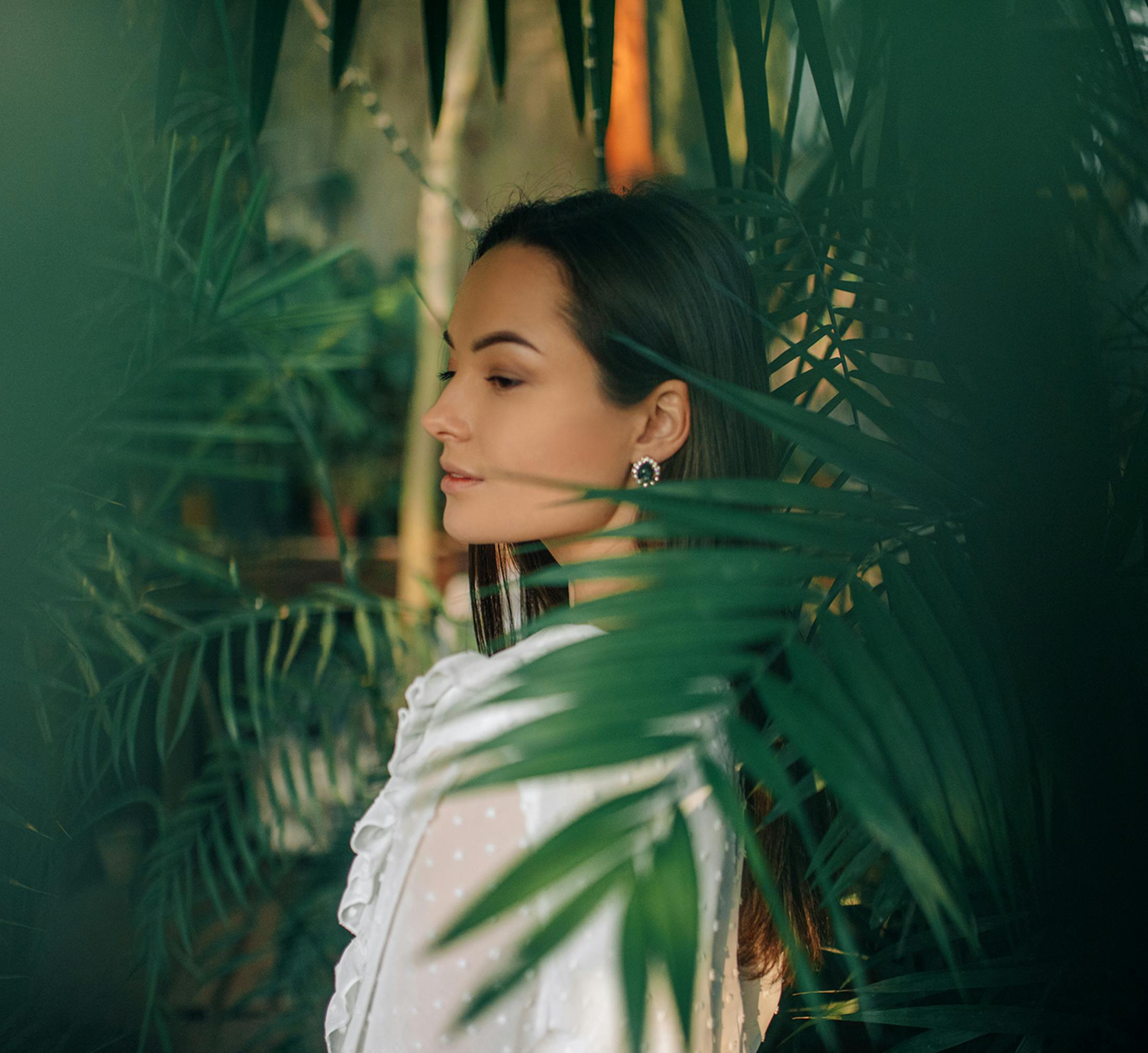 Woman looking over her shoulder behind leaves
