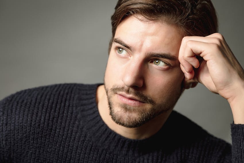 man looking to the side leaning head in hands