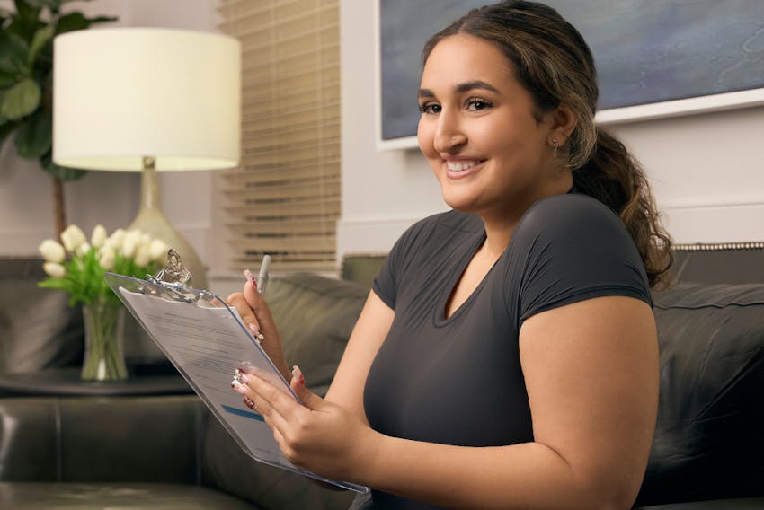 woman smiling holding clipboard'