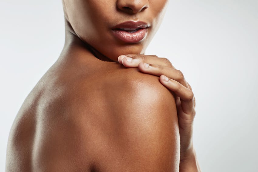 woman touching her shoulder