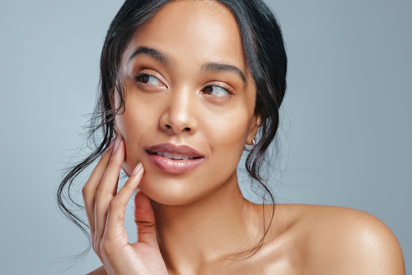 woman touching her cheek