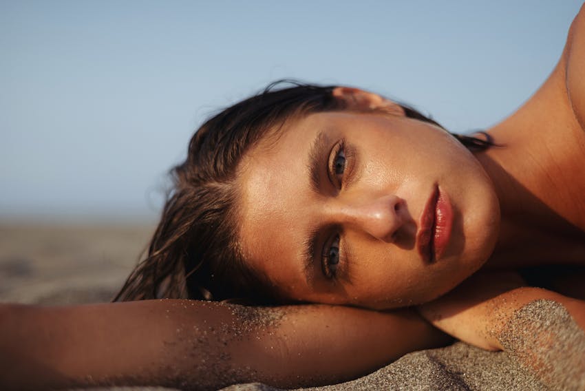 woman laying into sand