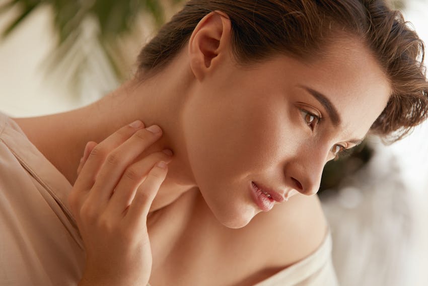 woman touching her neck