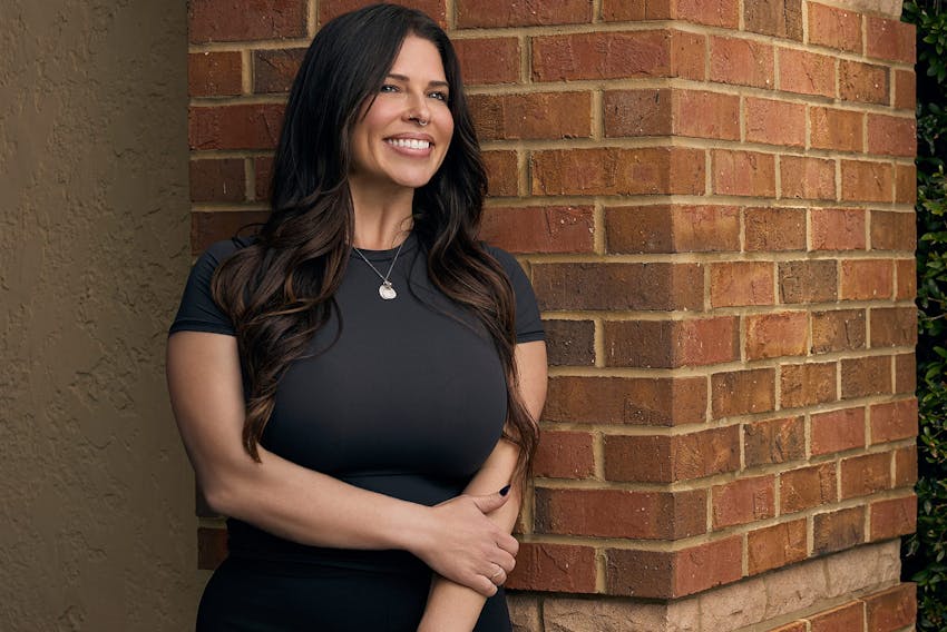 woman standing next to a brick wall