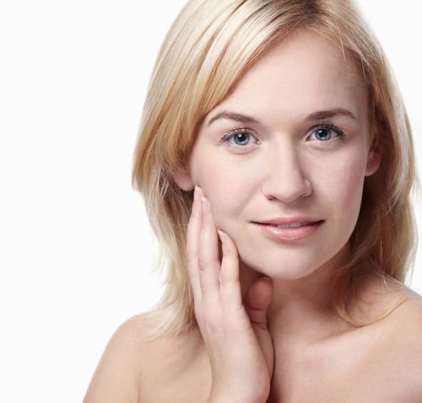 blonde woman touching her face