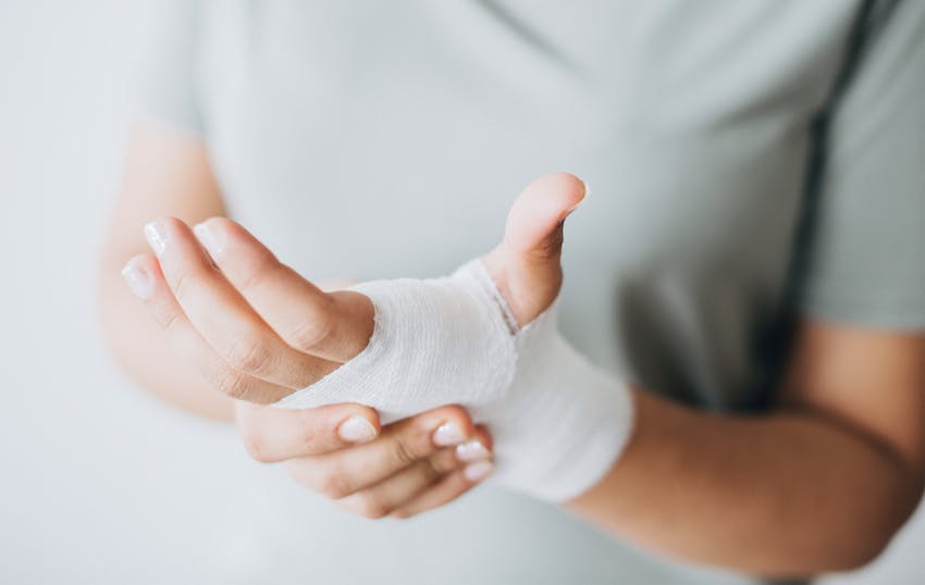 man holding his hand wrapped in gauze