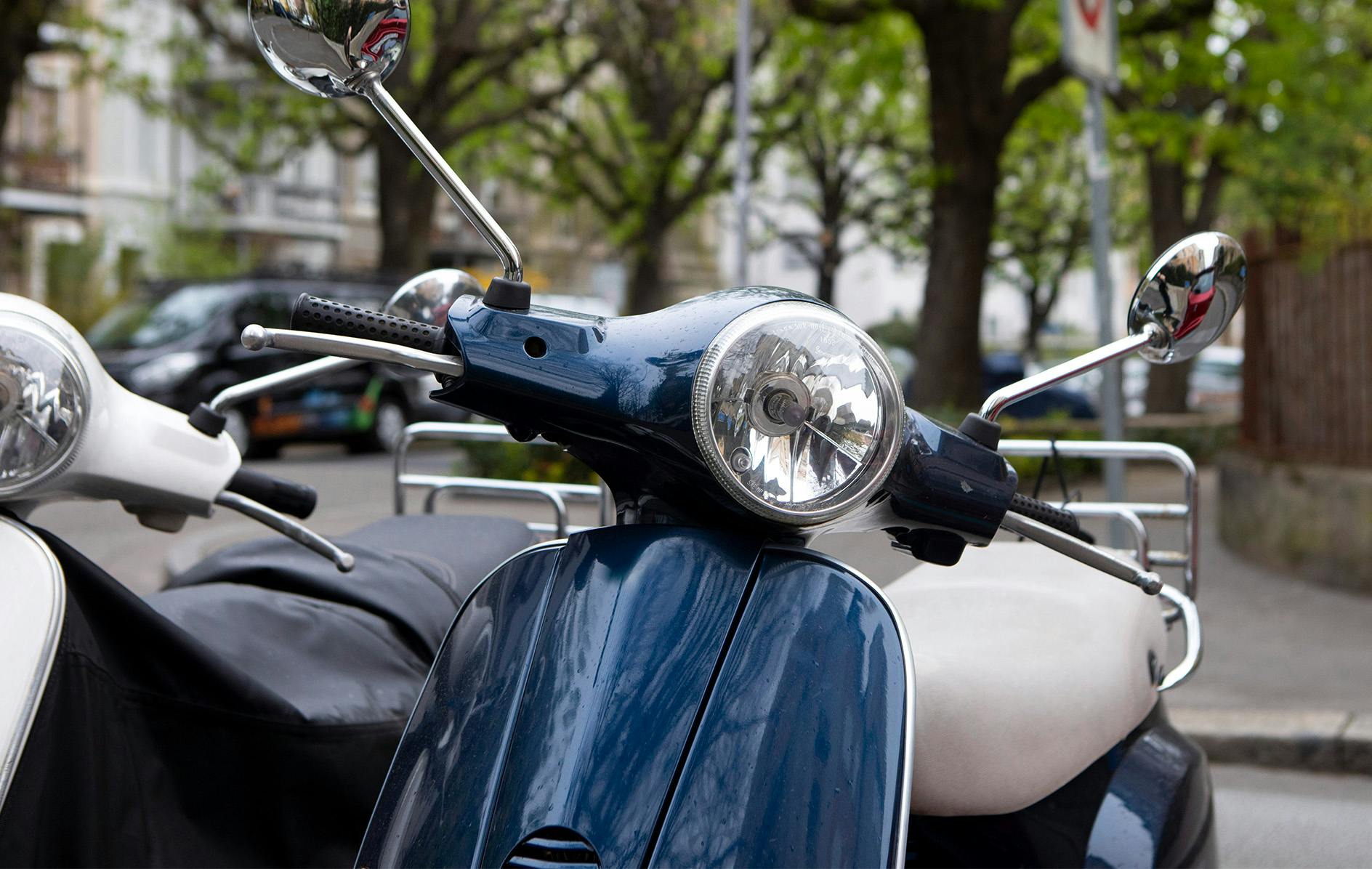 two mopeds parked on the side of the road
