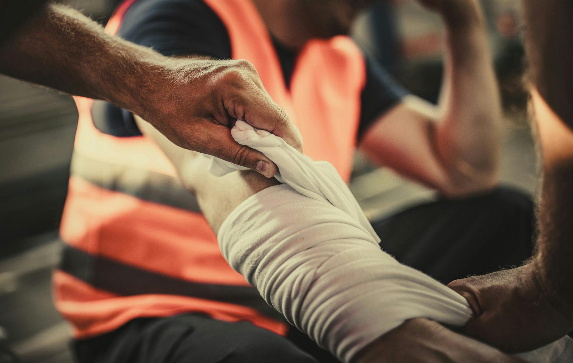 man getting his arm wrapped in cloth