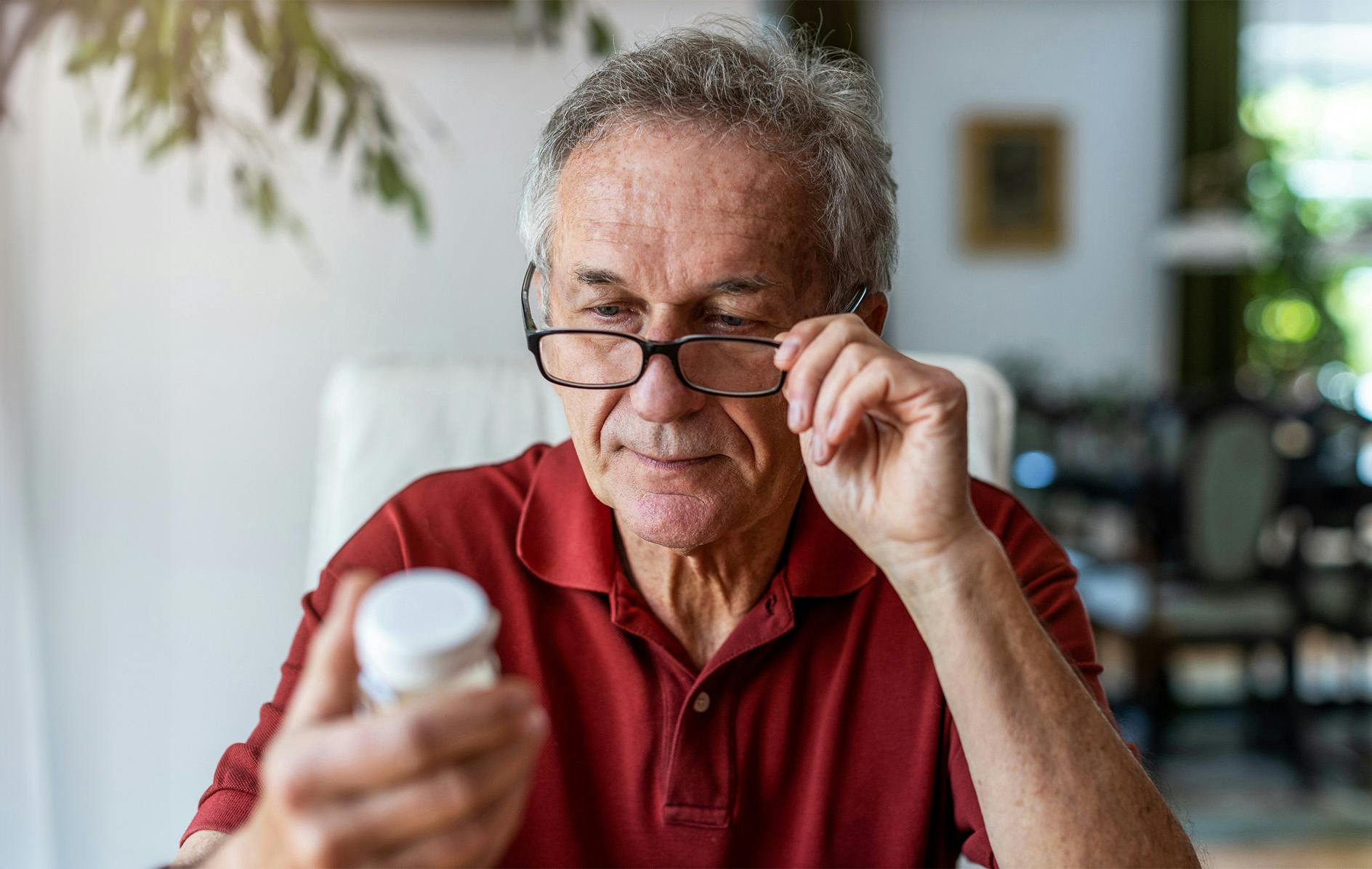 older man reading his pill bottle