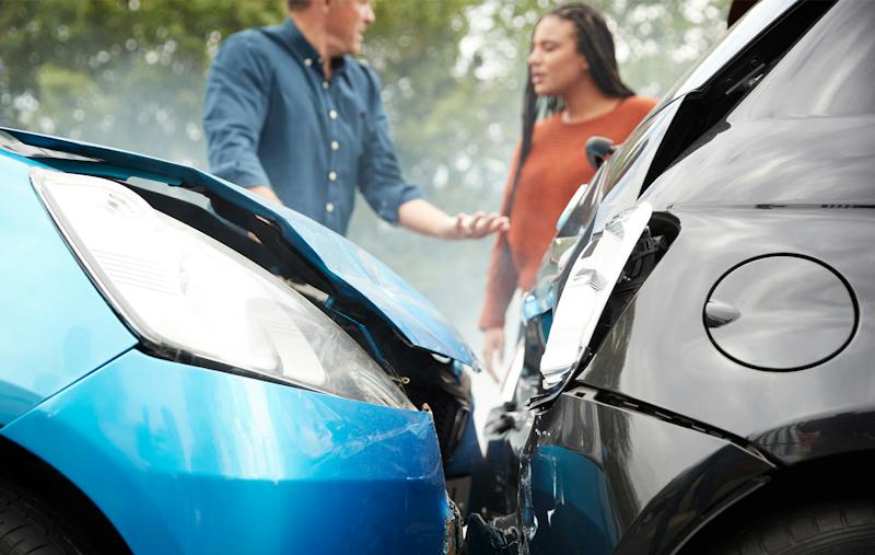two people arguing by a car accident