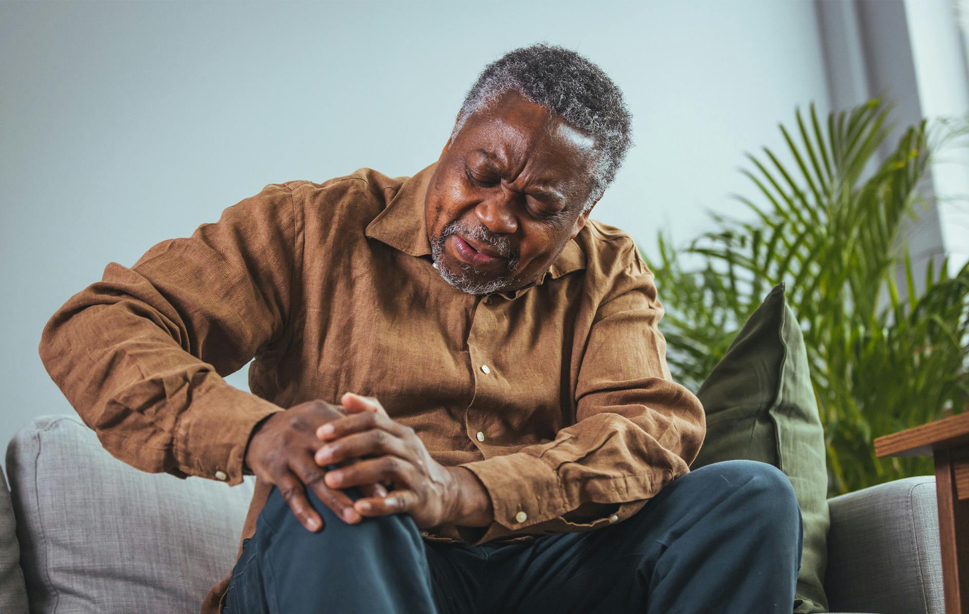 older man holding his knee in pain