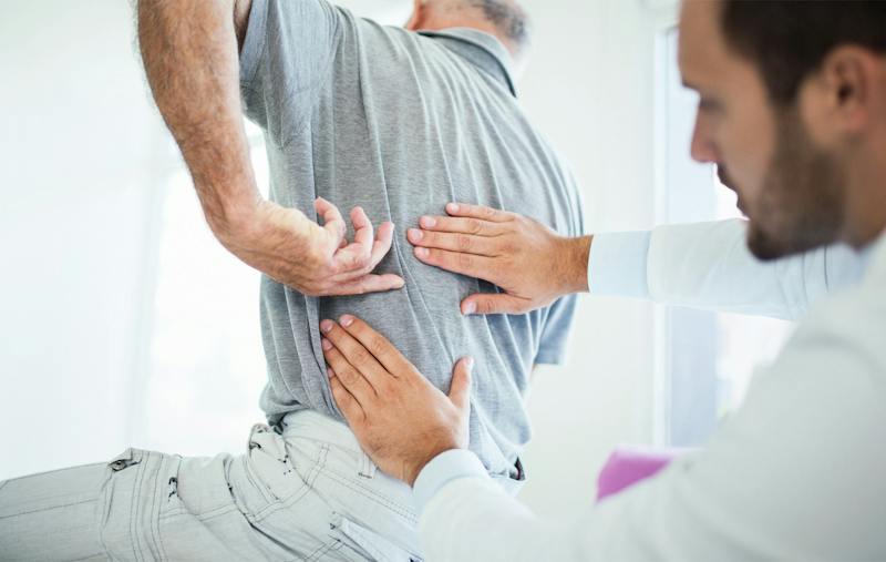 doctor checking a man's back
