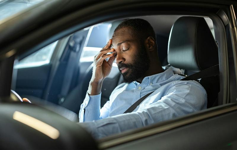 man in a car, holding his head