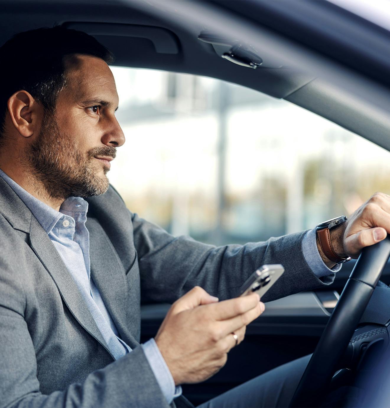 man holding his phone while driving