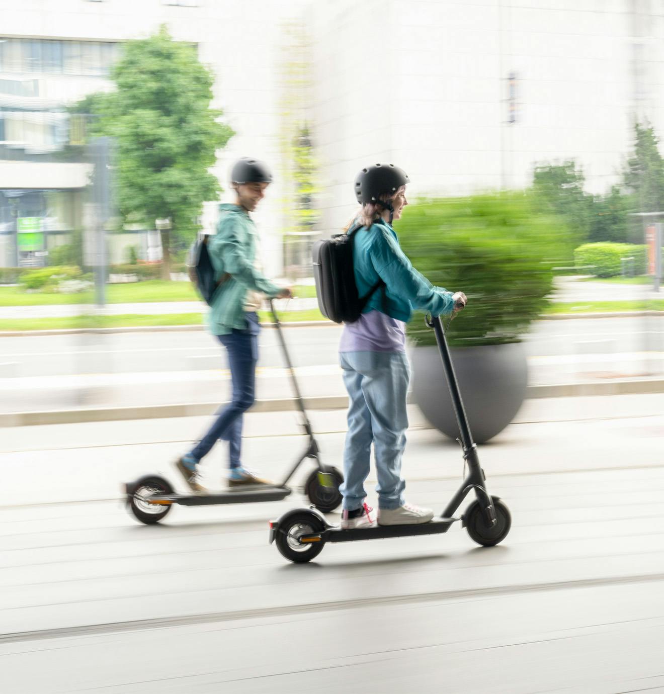 two people riding electric scooters