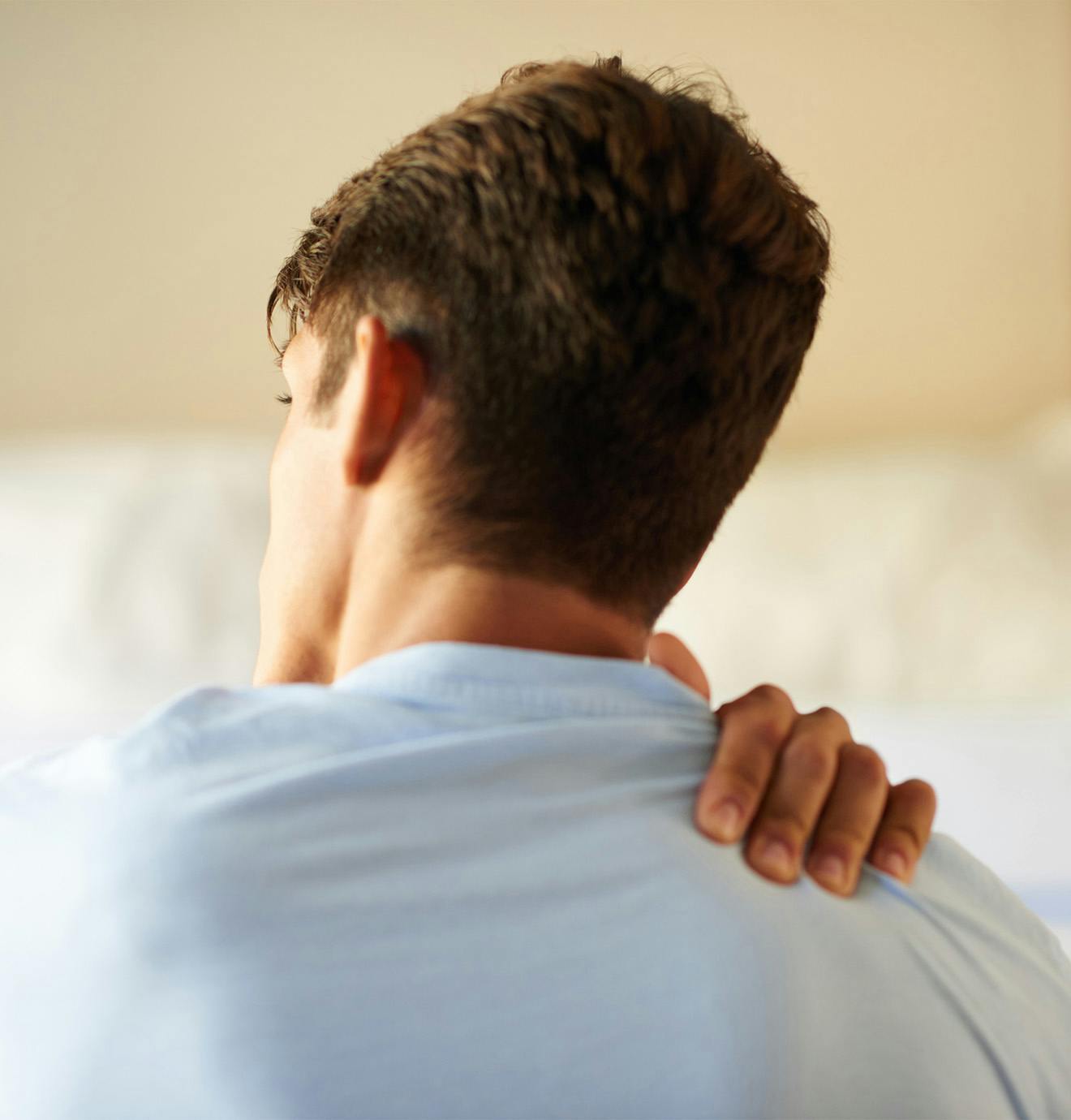 man holding his shoulder in pain