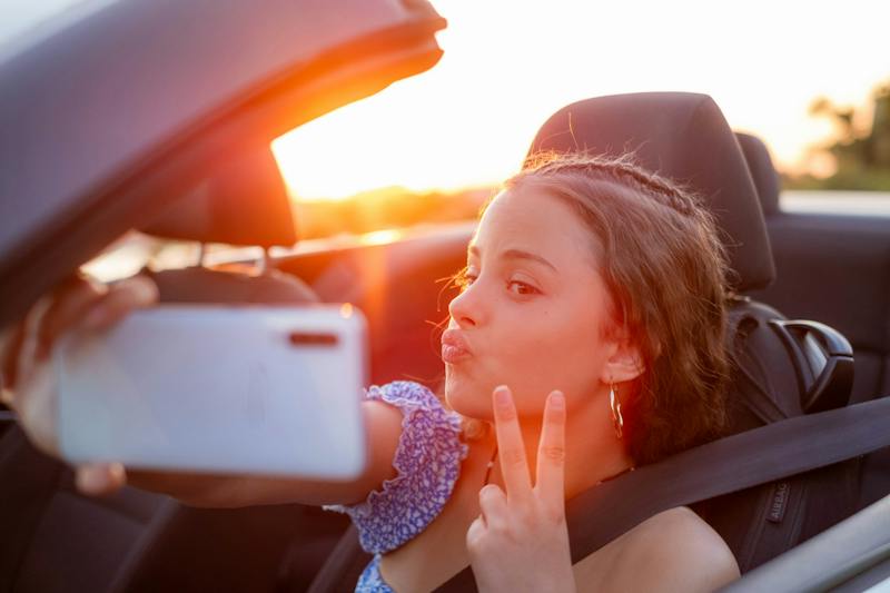 teenage girl taking a selfie in the car