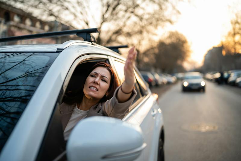 woman yelling out the window of her car