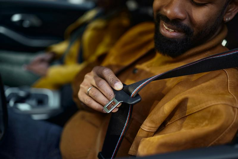 man puting on a seat belt