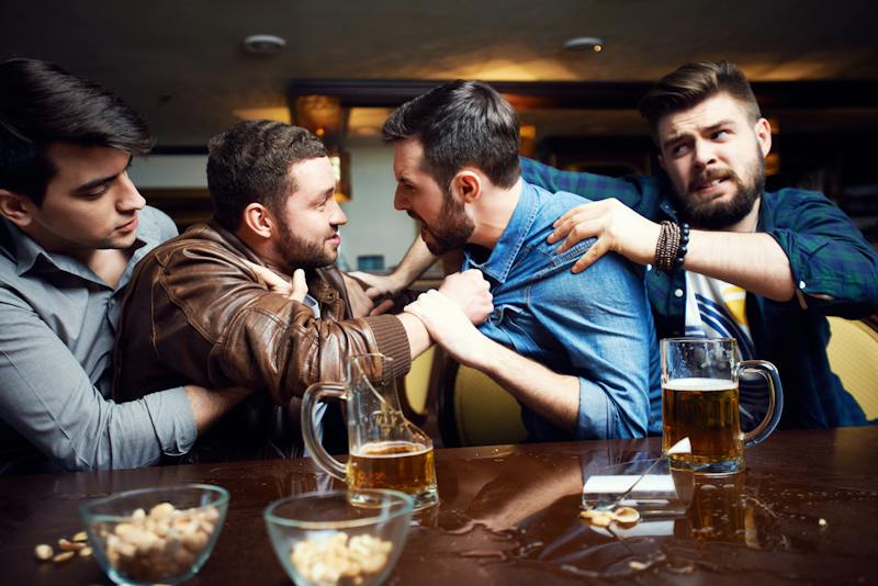four guys fighting at a bar