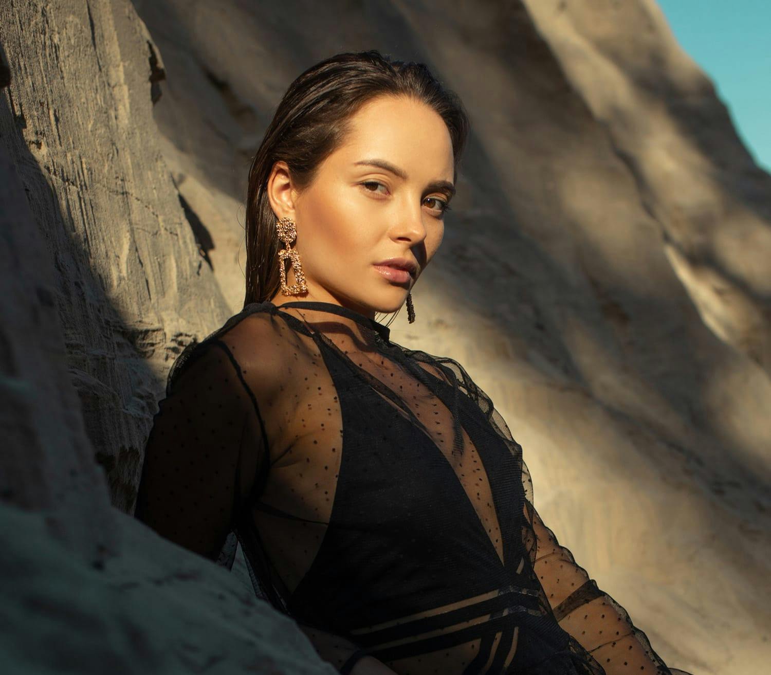 woman leaning against a rock
